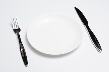 White plate with cutlery on white background