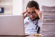 © Elnur - Young male employee unhappy with excessive work in the office