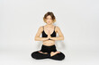 © SHOTPRIME STUDIO - woman in dark clothes sitting on the floor and meditation exercises for legs leggings