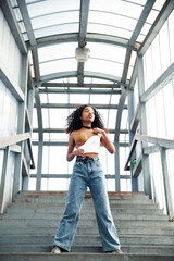 Wall Mural - young cute teenage african girl in industrial zone happy smiling having fun, big city lifestyle fashion people