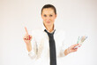 © Danko - Smiling business woman pointing up and looking at the camera over white background
