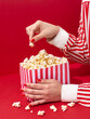 Red scene of hand holding a retro popcorn box