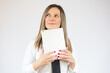 © Danko - Business caucasian woman holding tablet thinking on a white background