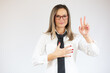 © Danko - Business woman showing victory sign isolated on white background.