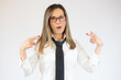 © Danko - Surprised young beautiful businesswoman pointing fingers at herself over white background.