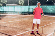 © fotofabrika - Middle-aged man tennis player with racket standing on court near net