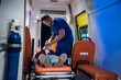 © Anna Kosolapova - A paramedic puts on an oxygen mask on an unconscious woman lying on stretcher in the ambulance car.