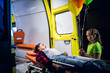 © Anna Kosolapova - Little girl standing beside a woman lying on a stretcher next to an ambulance, they look at each other.