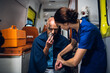 © Anna Kosolapova - A female paramedic checking her patient's pulse and asking him questions.