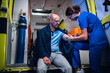 © Anna Kosolapova - A young nurse in a uniform giving an injection to a patient in an ambulance car.