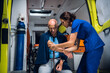 © Anna Kosolapova - Paramedic wraps a tourniquet around the hand of an injured man in an ambulance car.
