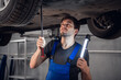 © Anna Kosolapova - A workmaninspects the bottom of a car with a flashlight