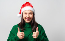 Young Woman In Christmas Hat Showing Thumb Up Gesture On A White Background.