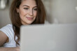 © muse studio - Training at home. The brunette woman smiles. portrait a foreign language teacher conducts a lesson remotely online conference with students via a video communication app.