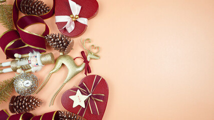 Luxury Christmas background with on trend fashionable stylish coral, deep red and gold gifts and decorations. Top view blog hero header creative composition flat lay with negative copy space.