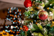 © gareth - Close up of gold Red bobble on christmas tree. chirstmas with lights reflecting in window at home. christmas concept. living room tree.