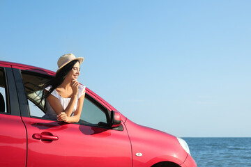 Canvas Print - Happy young woman leaning out of car window on beach, space for text. Summer trip