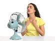 © New Africa - Woman suffering from heat in front of fan on white background. Summer season