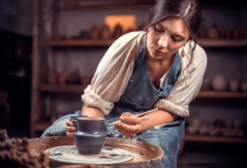 Wall Mural - Beautiful ceramist making ceramic pot on the pottery wheel . Handiwork.