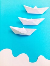 Close-up Of White Paper Boats Arranged On Blue Table
