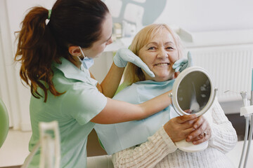 Senior woman having dental treatment at dentist's office. Woman is being treated for teeth