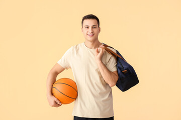 Sticker - Sporty young man with bag and ball on color background