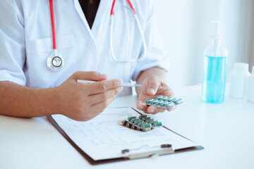 A doctor or nurse who writes medical reports or prescription lists on a clipboard on a hospital desk.