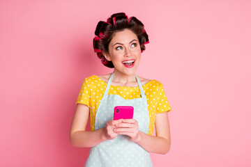 Wall Mural - Close-up portrait of pretty cheerful dreamy creative maid using device app 5g creating idea comment isolated on pink pastel color background