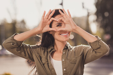 Poster - Photo portrait of stunning woman showing heart sign with fingers on eye outdoors