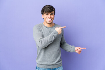 Wall Mural - Young cool man pointing with forefingers to a copy space, expressing excitement and desire.