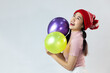 © CREATIVE WONDER - Portrait of cute asia woman wearing a red wool hat. Holding a balloon and smiling. On white background