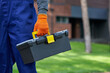 © Friends Stock - Ready for renovation work. Close up of builder carrying toolbox at construction site