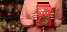 Woman Holds Red Mailbox For Letters To Santa Claus On The Christmas Background Close Up