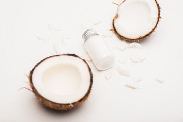 Wall Mural - bottle of homemade lotion near coconut halves and flakes on white 