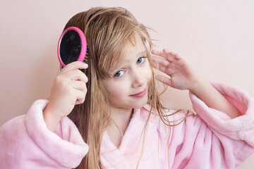 Wall Mural - little girl combs her hair after a shower