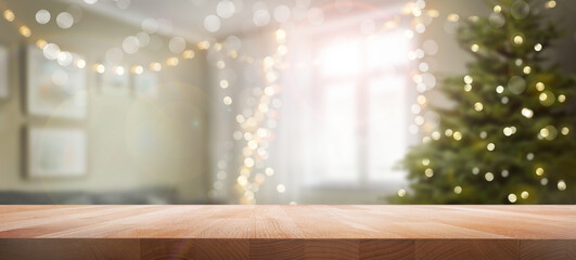 A wood table, tabletop product display with a festive living room Christmas background of Christmas tree and fairy lights.