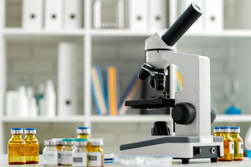 Vaccine bottles and microscope on table in a scientific lab