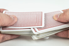 Hands Shuffling Playing Cards On White Background