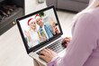 © Angelov - Caucasian woman at christmas, having video chat with friends and family using laptop. social distancing during covid 19 pandemic at christmas time.
