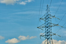 A Long Line Of Electrical Transmission Towers Carrying High Voltage Lines.
