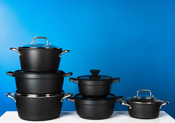 Set of black cookware against blue background