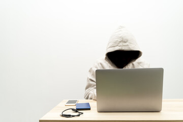 The Joker in the Shadows uses a laptop to steal information.