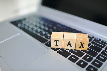 Business and tax concept with wooden block on laptop