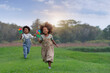 © chomplearn_2001 - Two dark skinned boys and girls play colorful toy pinwheels on beautiful summer days together. , spending time together outside in nature