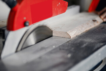 Wall Mural - Wood cutting with circular saw. Closeup of mature man sawing lumber.