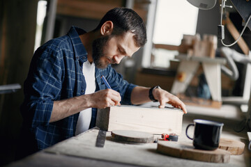 Wall Mural - Craftsman cutting a wooden plank. Worker with wood. Man in a blue shirt.