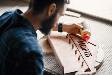 Wall Mural - Carpenter putting glue on a piece ofcedar wood. Man in a blue shirt.