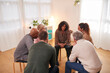 © Monkey Business - Group Consoling Woman Speaking At Support Group Meeting For Mental Health Or Dependency Issues