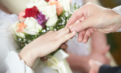 Priest puts on ring on brides and grooms finger during church wedding ceremony. Exchange of rings. Marriage concept. Wedding ceremony, bride, groom, exchanging rings