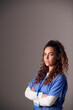 © Monkey Business - Studio Portrait Of Young Female Nurse Wearing Scrubs Standing Against Grey Background